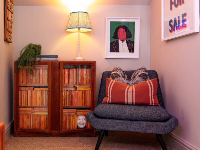 Stylish reading nook with vintage bookshelf and art at The Loft by the Bay.