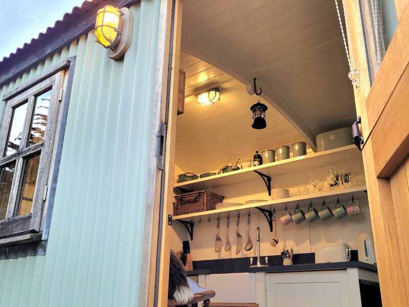Cozy kitchen interior of Plank Bridge shepherds hut, sleeps 2.
