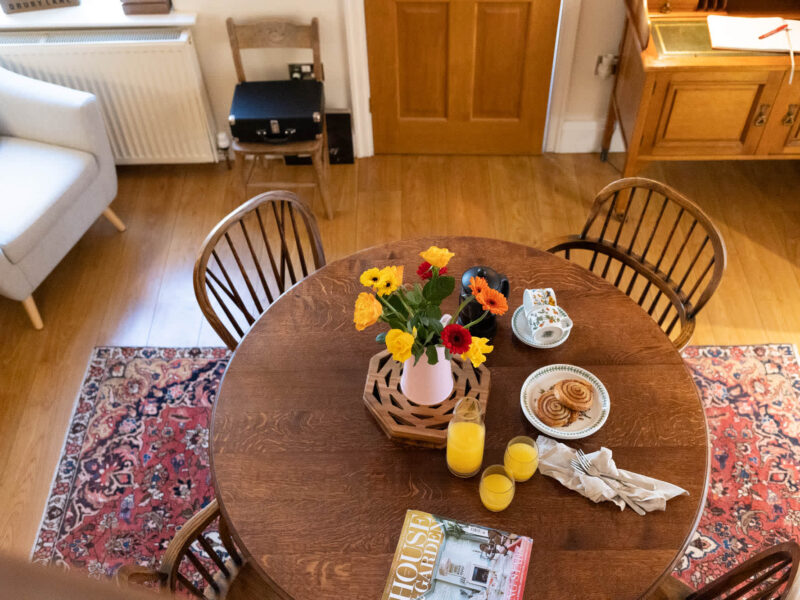 Dining table with flowers, coffee, and pastries at East Wing holiday let.