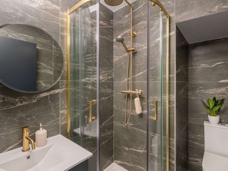 Modern marble bathroom with gold shower at Albemarle Chambers central retreat.