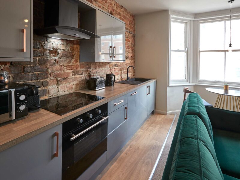 Modern kitchen with exposed brick and seating area at Umpires Watch.