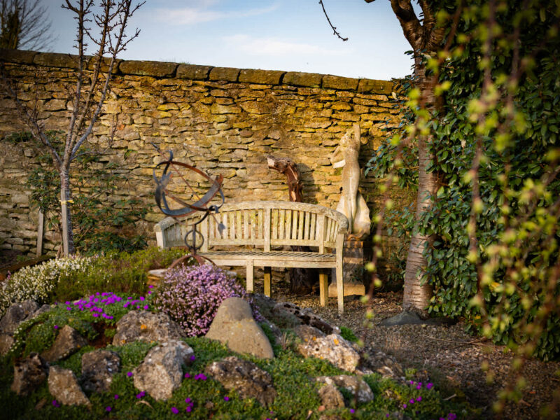 Plank Bridge shepherds hut garden with sundial and bench.