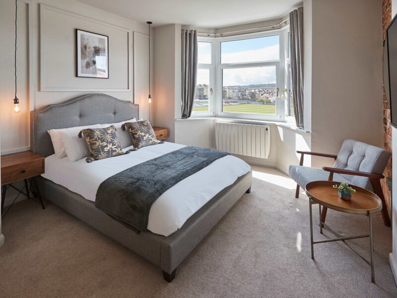 Comfortable bedroom with bay window views at Umpires Watch Cricket View.