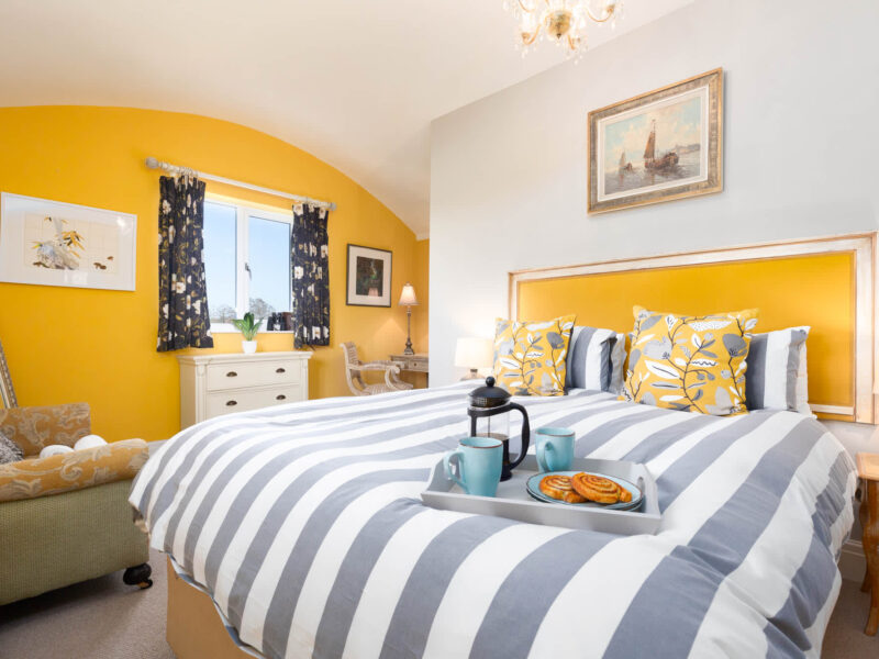 Bright bedroom with breakfast tray at East Wing holiday let.