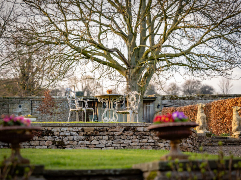East Wing garden seating area with country views and tennis court access.