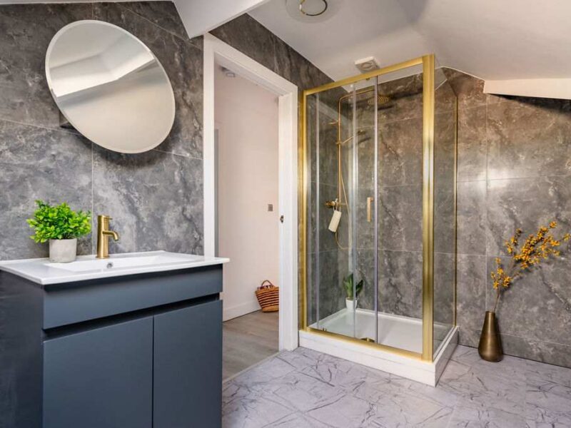 Modern bathroom with gold-trimmed shower at Albemarle Chambers central retreat.