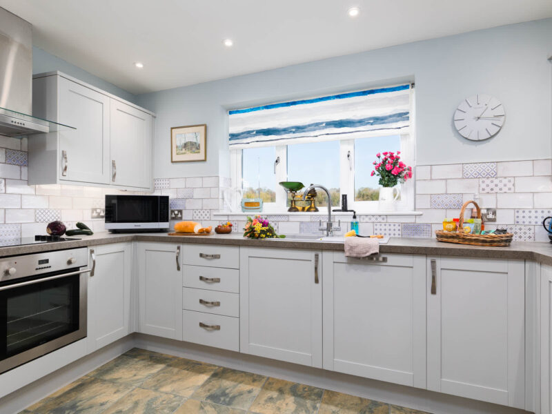 Modern kitchen with oven and microwave at East Wing holiday let.
