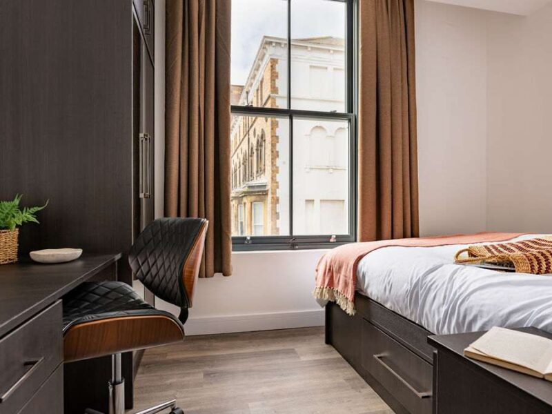 Stylish bedroom with desk and city views at Albemarle Chambers.