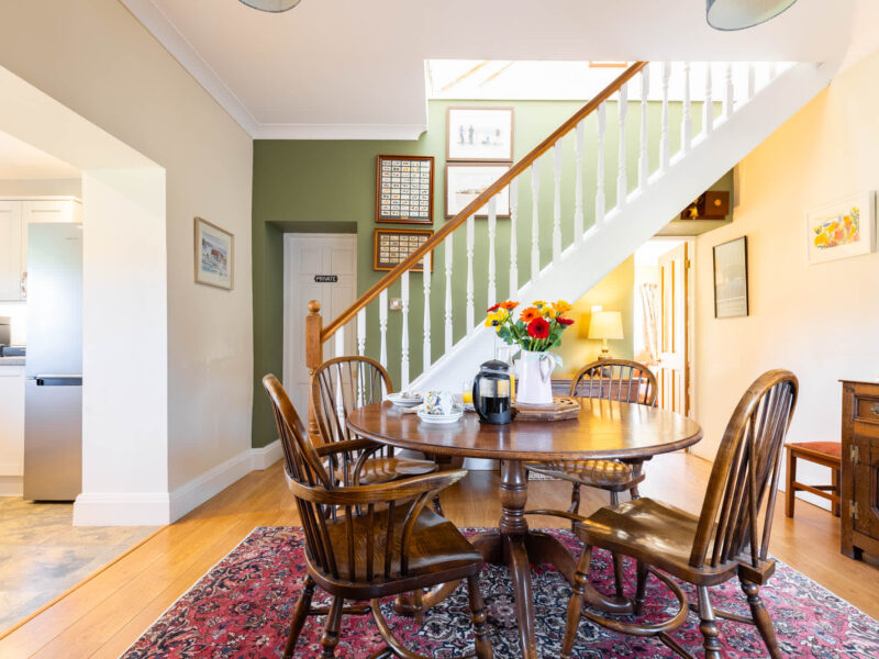 Dining area with wooden table and chairs at East Wing holiday let.