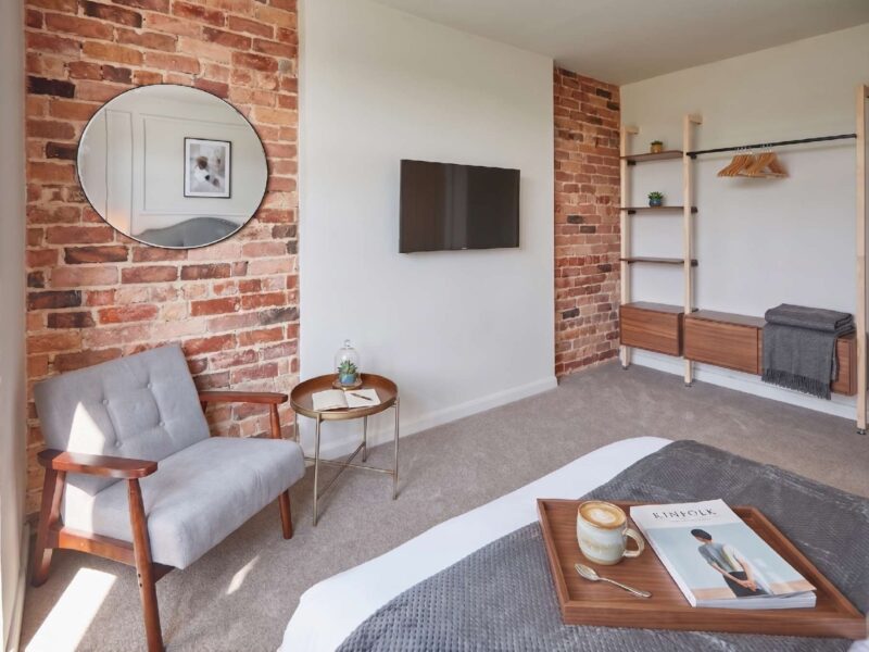 Stylish bedroom with exposed brick at Umpires Watch, Cricket View holiday let.