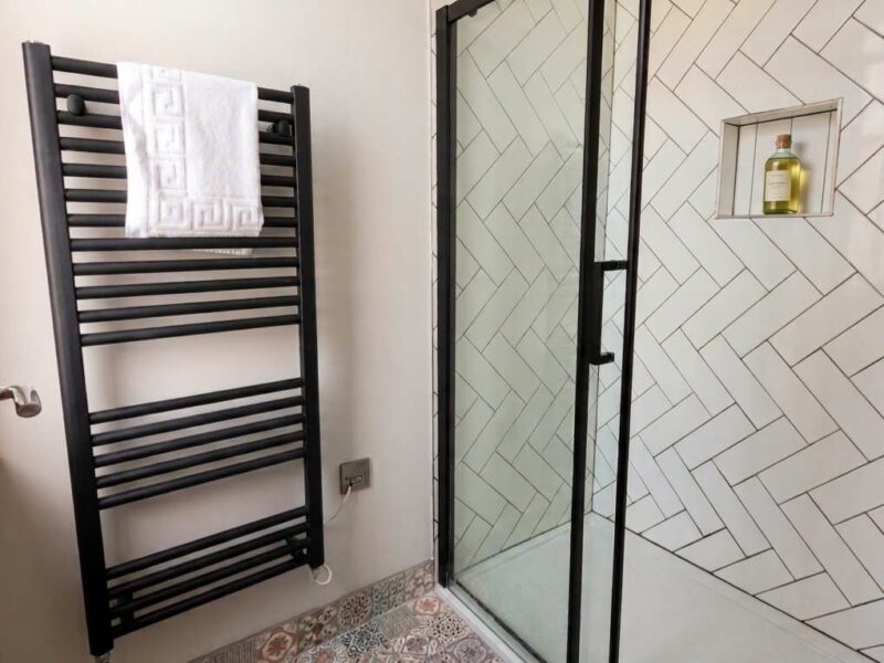 Modern bathroom with heated towel rail and walk-in shower at Umpires Watch.