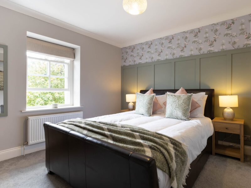 Luxury bedroom with floral wallpaper at Malton Retreat.