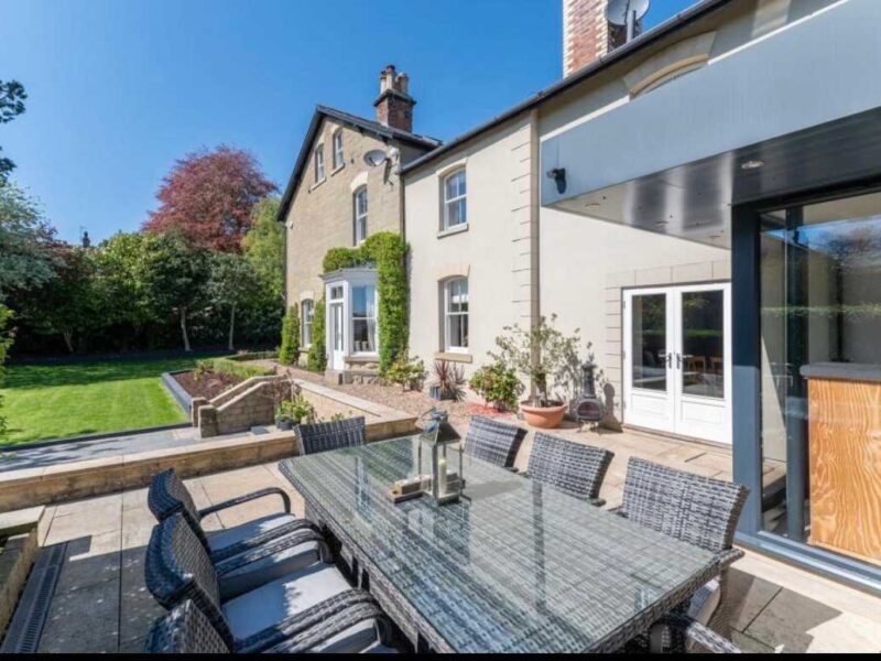 Malton Luxury Retreat patio with dining table and garden view.