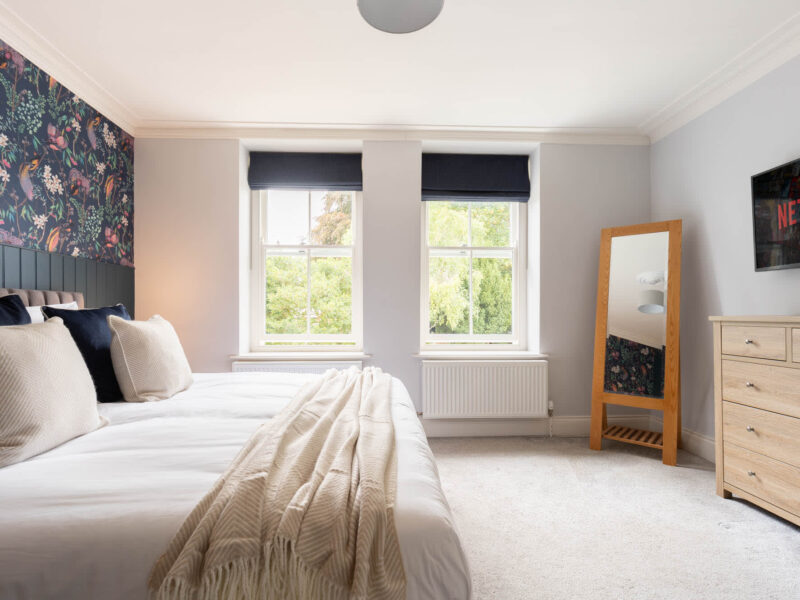 Luxurious bedroom with floral wallpaper at Malton Luxury Retreat.