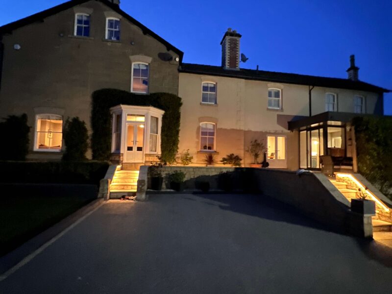 Malton Luxury Retreat exterior illuminated at dusk, welcoming guests.