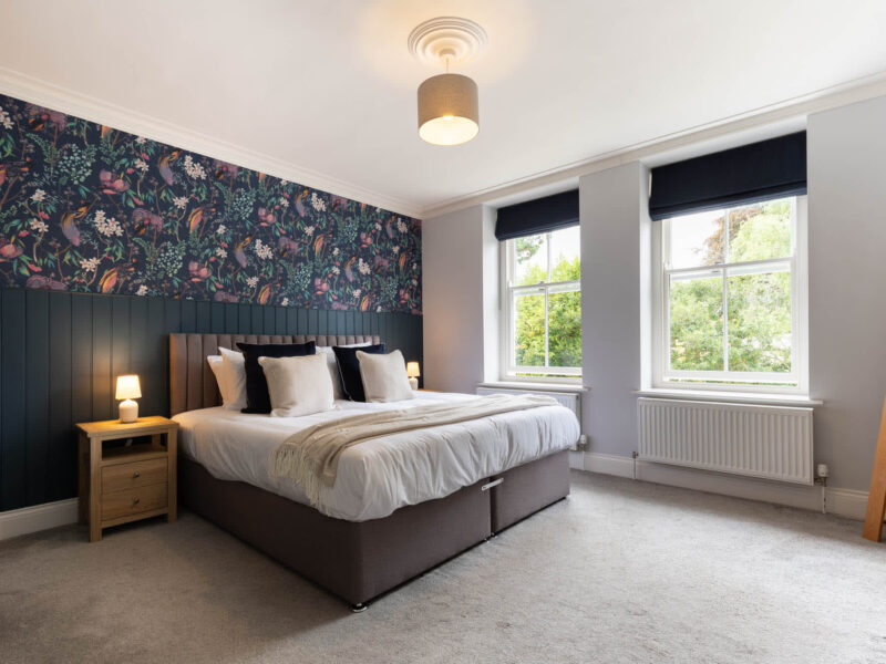 Luxurious bedroom with floral wallpaper at Malton Luxury Retreat.