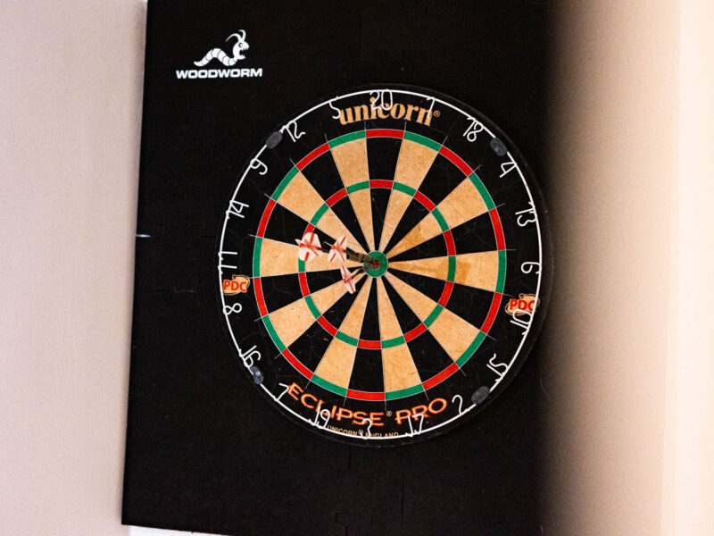 Dartboard with three darts in the bullseye at Malton Luxury Retreat.