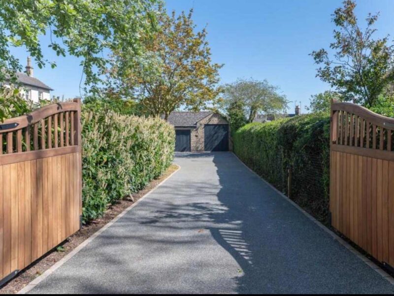 Malton Luxury Retreat driveway with wooden gates and garage.