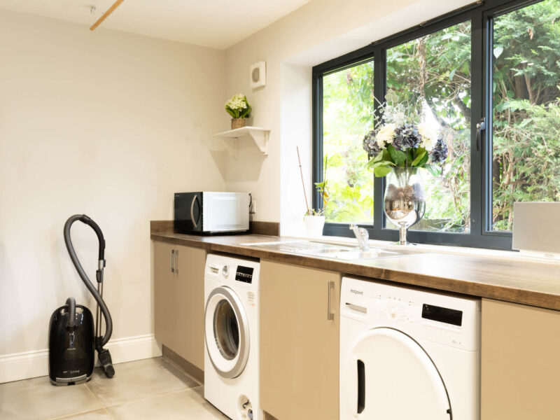 Laundry room with washer, dryer, and microwave at Malton Luxury Retreat.