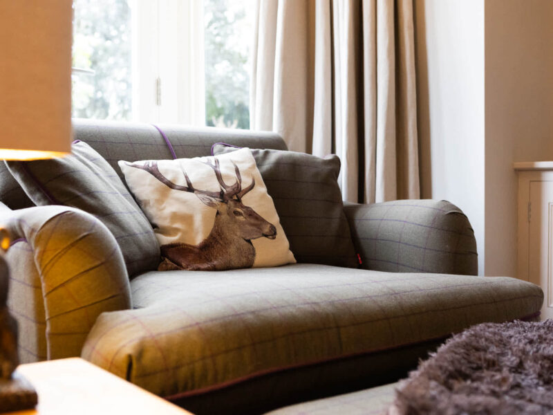 Comfortable sofa with stag cushion at Malton Luxury Retreat holiday let.
