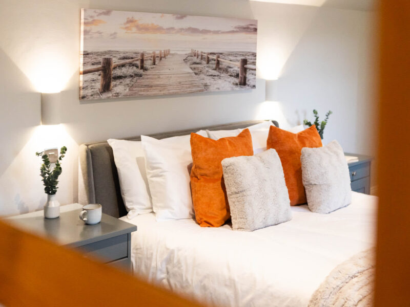 Comfortable bedroom with coastal art at Malton Luxury Retreat.